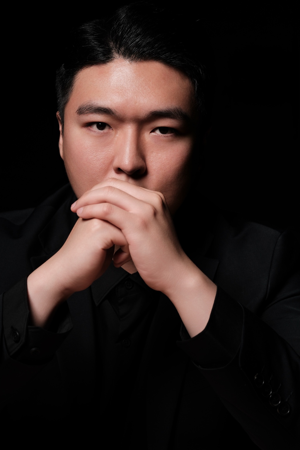 Stephano Park — portrait with hands clasped near the face
